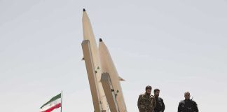 Iran’s SHOCKING Tanker Seizures — What’s Really Happening? Military personnel beside missiles and Iranian flag.