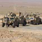 Castle Grab Explodes Lebanon Standoff Soldiers standing near armored vehicles in desert terrain.