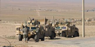 Castle Grab Explodes Lebanon Standoff Soldiers standing near armored vehicles in desert terrain.