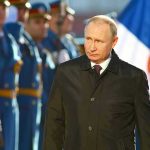Russian Deputy Minister’s SHOCKING Escape to US A man in dark coat at a military event.