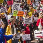 Missing Record Sparks AOC Controversy Crowd of protesters holding signs advocating for labor rights and social justice