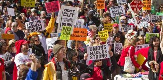Missing Record Sparks AOC Controversy Crowd of protesters holding signs advocating for labor rights and social justice