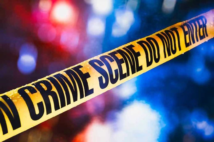 1019775253 Yellow crime scene tape with blurred lights background.