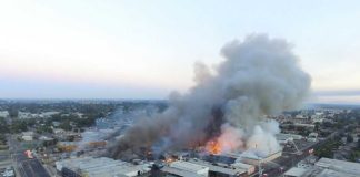 Aerial view of large industrial fire producing smoke