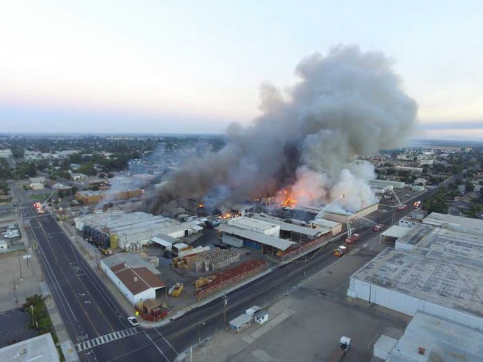 1062550499 Aerial view of large industrial fire producing smoke