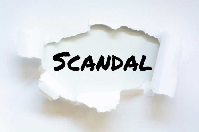 1925054051 Torn paper revealing the word SCANDAL.