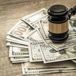 DNA Heist PAYOUT — Do YOU Qualify? Gavel on a pile of hundred-dollar bills.