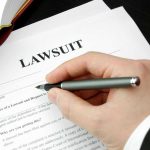 Texas JUDGE Finally WINS MAJOR Lawsuit — AFTER 11 YEARS! Hand holding pen, filling out lawsuit form.