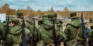 Group of soldiers in camouflage uniforms walking in an outdoor training environment