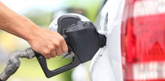 Oil Craters on PHANTOM Peace Deal — What This Means For You A hand holding a fuel nozzle while refueling a white vehicle at a gas station
