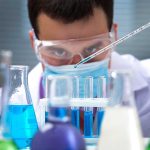 Ukraine BIOLABS — What Did Obama REALLY Back? Scientist conducting an experiment with blue liquids in a laboratory