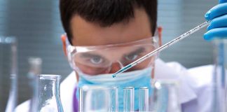 Ukraine BIOLABS — What Did Obama REALLY Back? Scientist conducting an experiment with blue liquids in a laboratory