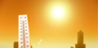 Rare RED Extreme Heat WARNING ISSUED Thermometer displaying high temperature against a sunset city skyline