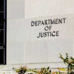 EXPOSED! — Fake US Charity FUNNELED Cash To HAMAS Sign on the exterior wall of the Department of Justice building