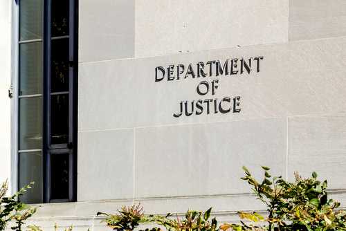 Sign on the exterior wall of the Department of Justice building