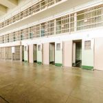 Judges Slam BIZARRE Jail Experiment Interior view of a prison cell block with empty cells and security bars