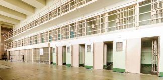 Judges Slam BIZARRE Jail Experiment Interior view of a prison cell block with empty cells and security bars