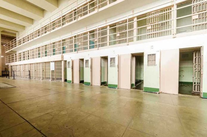 shutterstock_206092135 Interior view of a prison cell block with empty cells and security bars