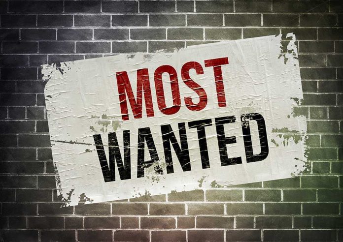shutterstock_227310661 A weathered poster displaying the words MOST WANTED on a brick wall