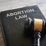SHOCKING — DISTANT CITY Judges REWRITE Abortion Rules NATIONWIDE! A gavel resting on a book titled 'Abortion Law'