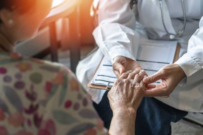 shutterstock_2396448165 A doctor holding the hand of an elderly patient during a consultation