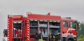 Firefighter accessing equipment on a parked fire truck