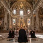 Bishop Shot At Home — Motive Missing Individuals kneeling in prayer inside a grand cathedral