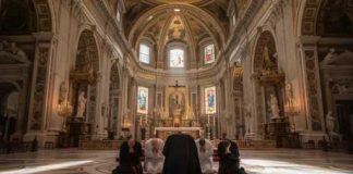 Bishop Shot At Home — Motive Missing Individuals kneeling in prayer inside a grand cathedral