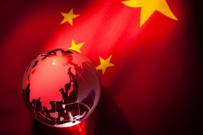 shutterstock_71395978 A globe illuminated against the backdrop of the Chinese flag