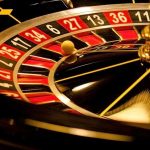 Mega Warship GAMBLE — Critics Smell Boondoggle Close-up of roulette wheel with spinning ball.