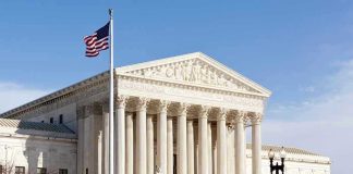 Shocking REVERSAL: Trump Checked — TWICE! United States Supreme Court building with American flag.