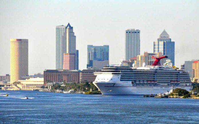 cruise-ship430992302 Cruise ship docked near city skyline and water.