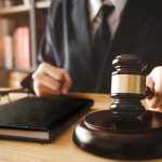 Judge with gavel striking sound block