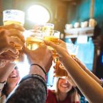 Beloved Brewery in PERIL — Valid VIOLATIONS or VENGEANCE? Group toasting with beer glasses in a pub