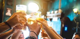 Beloved Brewery in PERIL — Valid VIOLATIONS or VENGEANCE? Group toasting with beer glasses in a pub