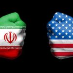 Fists painted as Iran and United States flags facing each other