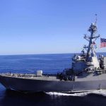 Ten Nights Of BOMBS — What’s The ENDGAME? Naval destroyer sailing on open sea with flag flying