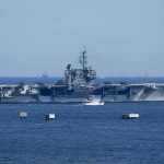 SURPRISE Drone Swarms TARGET U.S. Carriers Aerial view of multiple naval ships operating in the ocean