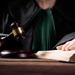 Teen Killer Drops BOMBSHELL PLEA Judge in robe holding gavel beside open law book