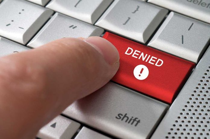shutterstock_145675649-1 A finger pressing a red DENIED button on a computer keyboard