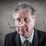 man with a long wooden nose in a suit