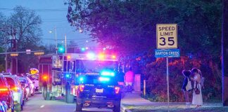 Emergency vehicles with flashing lights on a city street at night
