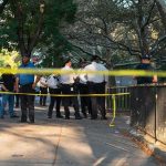 Pool SCARE Tied To GABBARD Police officers gather behind yellow tape on a tree-lined sidewalk