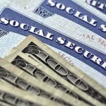CRISIS — 22% Social Security Cut Looms Social Security cards with U.S. dollar bills
