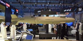 Two large guided munitions displayed at a defense trade show