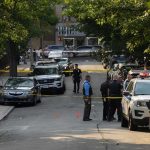Knife Yell. Taser Misfire. Then BOOM. Police officers secure a residential street with patrol cars and yellow tape