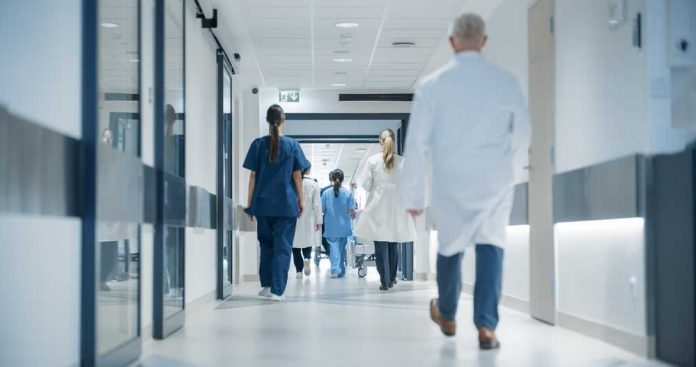 shutterstock_2557673781 Medical staff walking through a hospital corridor