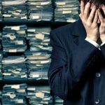 Biden SECRET Tapes EXPOSED — What’s HE Trying To HIDE? Man in suit covering face beside stacks of paperwork