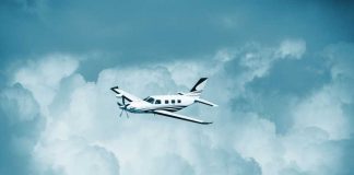 Small turboprop airplane flying through cloudy sky