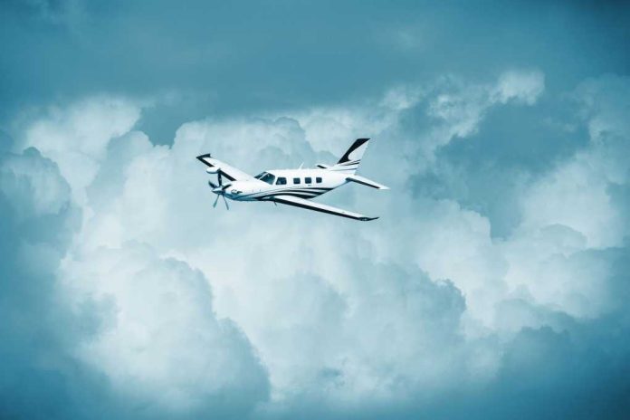 Small turboprop airplane flying through cloudy sky